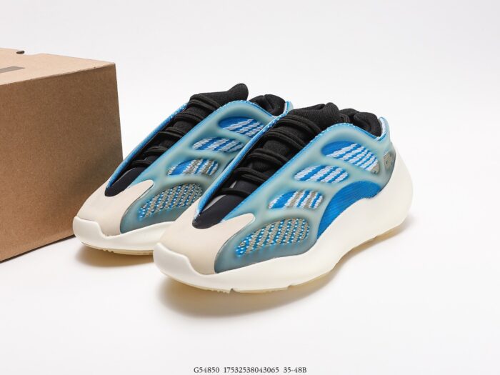 Blue-grey sneakers with black details next to a branded shoebox