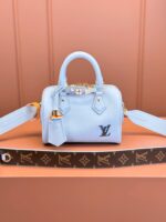 Light blue Louis Vuitton handbag with leather material, metal charms, and detachable strap.